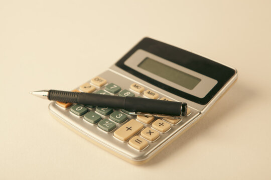 calculator and pen on white background