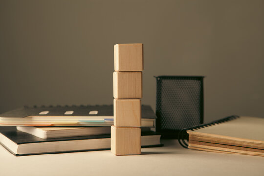 Wooden block stacking as step stair on book and notebook for business content.