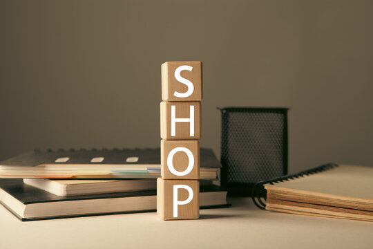 The word SHOP is written on wooden cubes on a gray background.