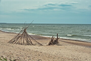Wooden Driftwood Tipi Wigwam Structure on Sandy Baltic Sea Beach © Daniel