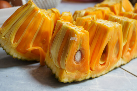 Cut yellow jackfruit showing a seed inside the sweet fleshy pod