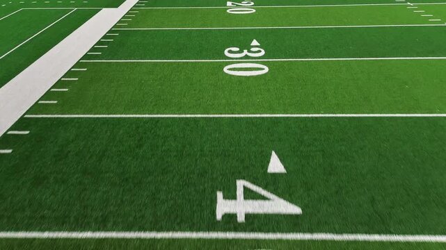 American football field low POV flyover showing yard lines and hash marks
