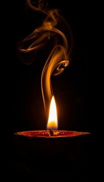 A beautiful traditional clay diya glowing with a bright flame. The smoke rising from the flame forms a highly detailed, glowing ethereal silhouette of Lord Ganesha