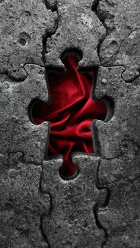 Abstract textured stone jigsaw puzzle with a missing piece revealing red silk fabric beneath as concept of passion and mystery