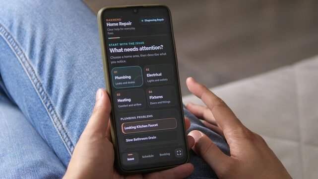 Homeowner uses a mobile repair app to report a leaking kitchen faucet, reflecting the growing shift toward on-demand home maintenance, digital diagnostics and service booking.