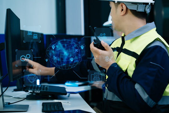 Industrial engineer with walkie talkie monitors global logistics, flight tracking, and network data on a futuristic control room