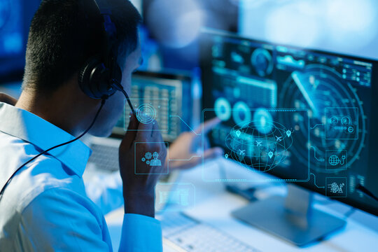 A professional operator with a headset monitors global aviation and logistics data on a futuristic digital radar HUD screen