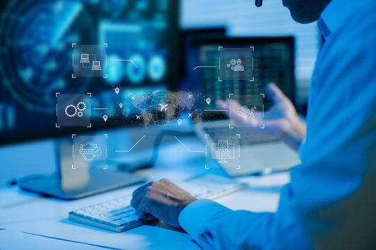 IT professional analyzes global logistics and circuit data via futuristic HUD screens. A headset rests on the desk