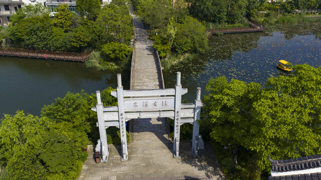 Aerial view of traditional Chinese stone gate and bridge over lakeside park