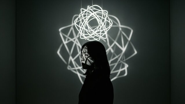 Art - Asian woman standing under glowing geometric neon light installation