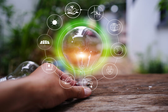 Hand Holding Light Bulb with Renewable Green Energy Icons