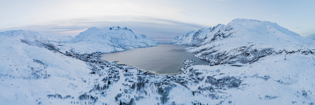 View of ersfjorden fjord sunset with snowy mountains and village