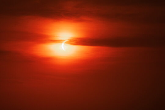 Solar eclipse over red morning sky in valldemossa Mallorca