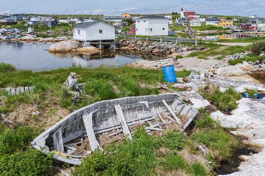 Abandoned wooden boat resting on rocky shore in greenspond harbor