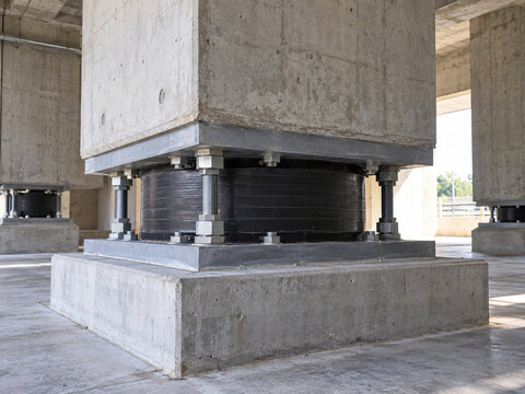 Seismic base isolator beneath reinforced concrete structural column