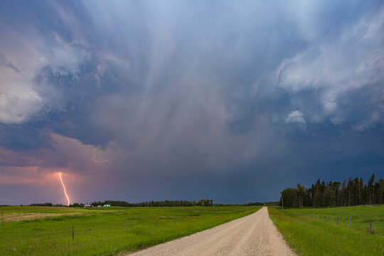 Lightning striking farm road with stormy skies