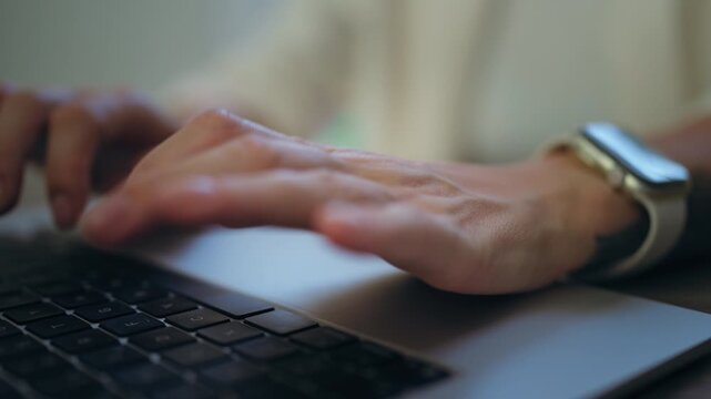 Close-up of a professional woman's hands actively typing on a laptop keyboard, representing business communication, freelance work, or programming in a modern office