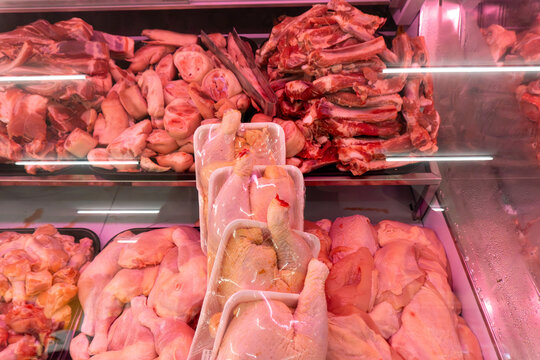 Raw chicken and beef displayed in refrigerated case