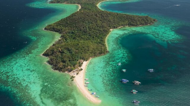 Drone footage of Bulog Dos Island, a popular island-hopping destination near Coron, Palawan, showing the island's distinctive sandbar, shallow turquoise waters, coral reefs and tropical landscape.