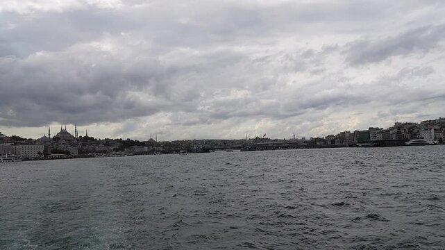 ISTANBUL, TURKEY - SEPTEMBER 23, 2026: Passenger ferry sailing on the Bosphorus Strait in Istanbul with scenic clouds, seagulls, and city skyline in the background.
