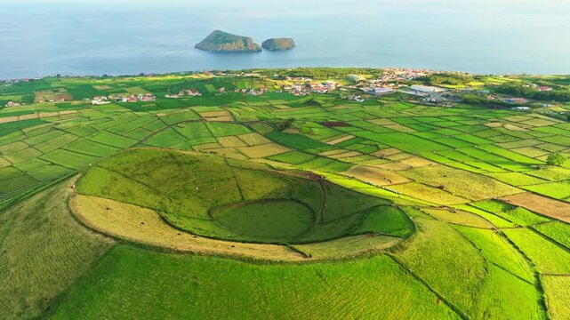 Pico Dona Joana Volcanic Cone, Patchwork Fields, Pasturelands and Cabras Islets at Sunset. Atlantic Ocean. Terceira Island, Azores, Portugal. Aerial View. Orbiting