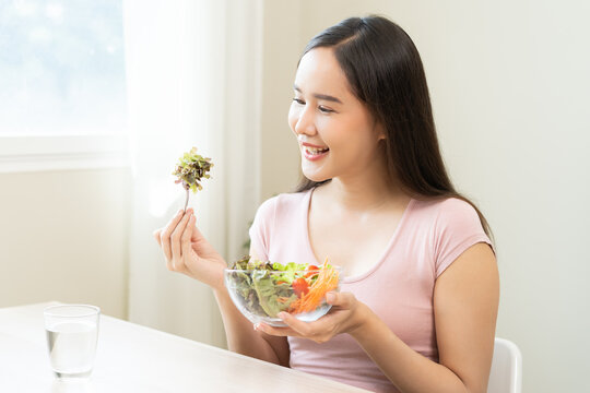 Diet concept, happy smile asian young woman use fork to prick lettuce, fresh vegetable or green salad, eat nutrition food isolated on background, low fat to good body, getting weight loss for healthy.