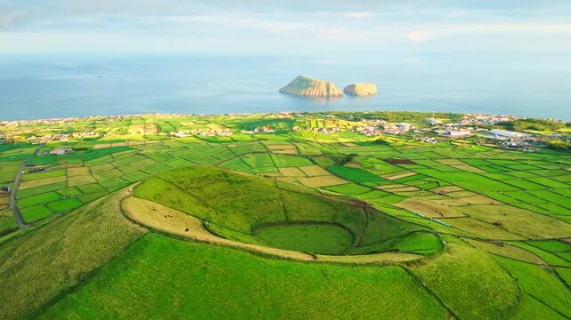 Pico Dona Joana Volcanic Cone, Patchwork Fields, Pasturelands and Cabras Islets at Sunset. Atlantic Ocean. Terceira Island, Azores, Portugal. Aerial View. Orbiting