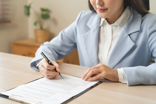 Business finance concept, asian young woman hand document signing contract, holding pen putting signs signature paper at desk office. Agreement legal commitment job, approval permission confirmation.