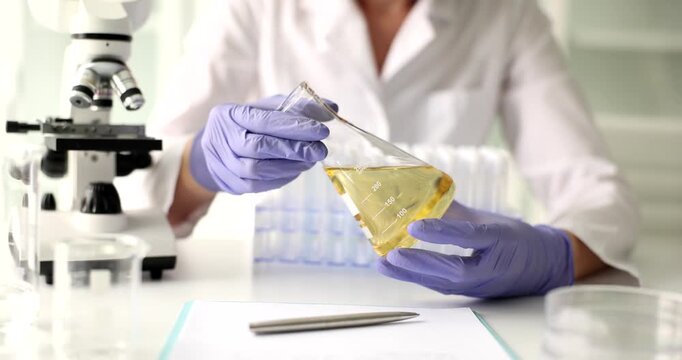 A researcher in a clean laboratory carefully mixes liquids in a flask, showcasing precision and attention to detail. The atmosphere is vibrant and inquisitive, filled with the tools of science.