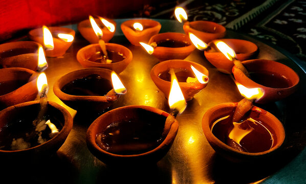Glowing Clay Diyas on Plate for Diwali Celebration
