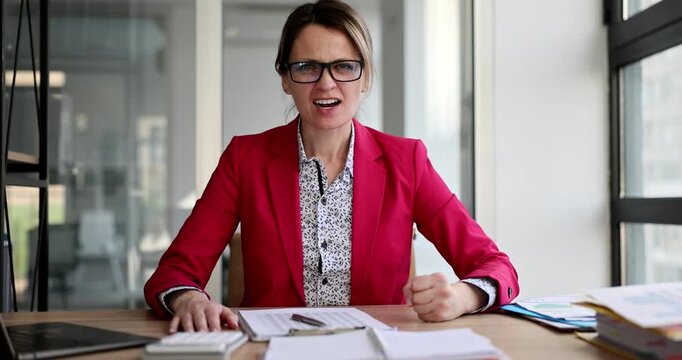 A woman in a red blazer showcases a range of emotions at her desk, transitioning from focused determination to vibrant excitement. Her dynamic expressions highlight the energy of the moment.