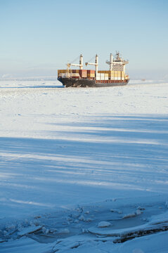 Winter shipping. Big cargo ships in ice sea fairway