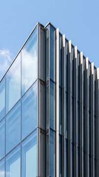 Sharp glass corner facade forms a crisp geometric abstract office building pattern