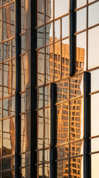 Warm reflective glass facade forms a layered geometric abstract skyline pattern