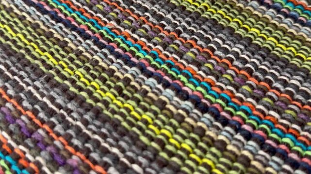 Traditional handwoven textile rug displaying colorful lines. Rustic homemade home decor background, authentic craft material backdrop, cozy winter design. Knitted textile pattern.
