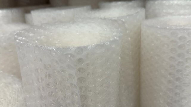 Roll of transparent plastic bubble wrap packaging material. Industrial packing supplies, shipping protective insulation.