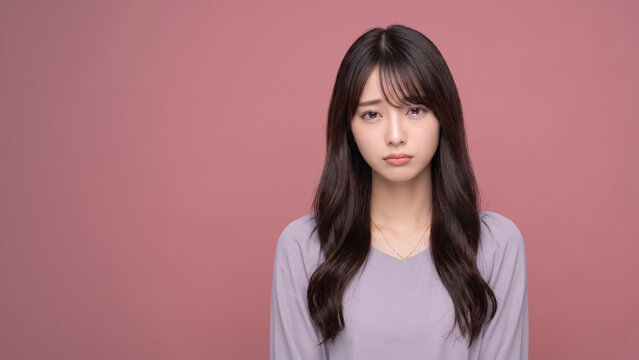 切ない表情でカメラを見つめる悲しげな女性