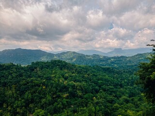Fototapeta premium Scenic panoramic view of lush green mountains and tropical forests from Kadugannawa viewpoint in Sri Lanka