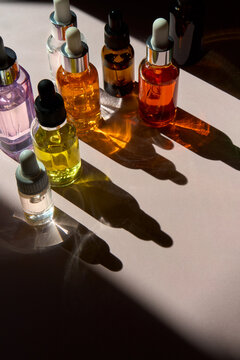 Colorful Serum Dropper Bottles in Sunlight and Shadows with Copy Space