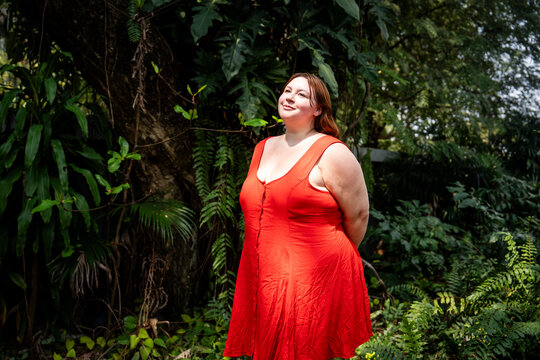 Portrait of a redhead Gen-Z girl in a tropical fern garden in Bangkok