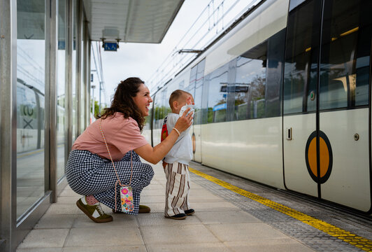 Mother and toddler waiting at train station platform