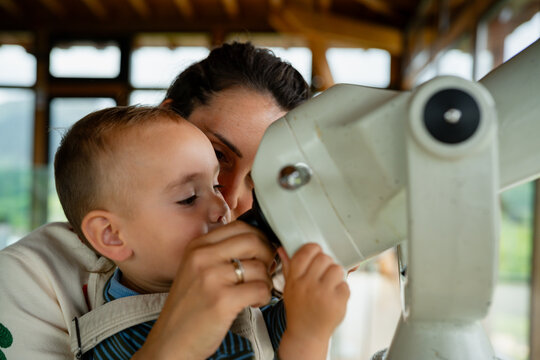 Mother and child observing with a viewing telescope