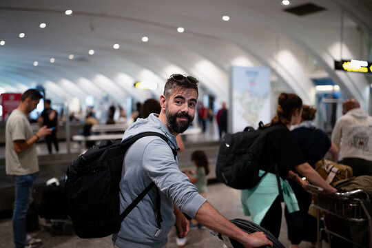 Man traveler with backpack arriving at a busy airport