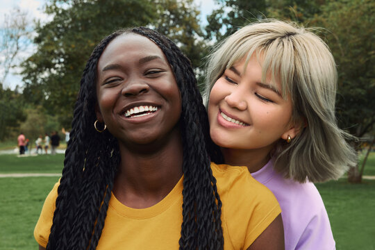 Diverse women friends smiling in park expressing happiness