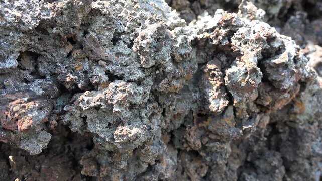 Spongy porous broken basalt stones with dark volcanic texture rough vesicular surface detail.