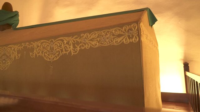 Cloth covered caskets rest inside Islamic tomb, sacred interior reflecting spiritual mourning.