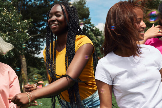 Young women from diverse backgrounds laugh and enjoy the outdoors
