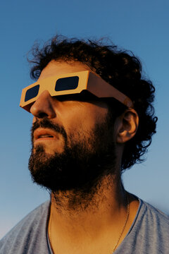 Man watches solar eclipse while wearing special glasses