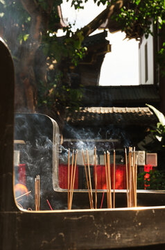 Closeup of burning incense in a large burner at an Eastern temple