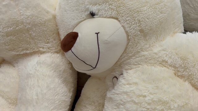 Close up of huge soft white teddy bears plush toy. Childhood comfort, fluffy stuffed animal, nursery decoration.